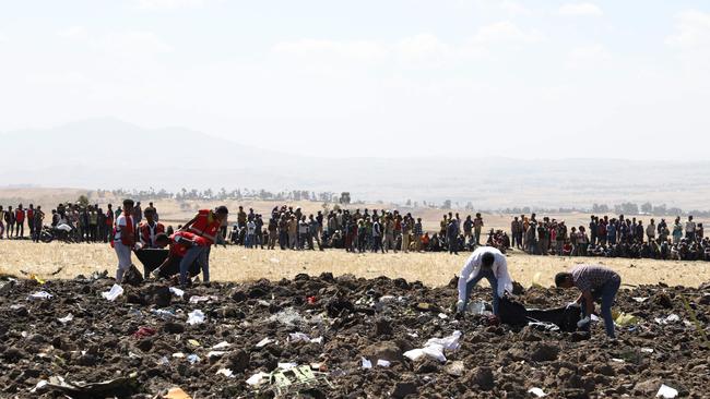 Rescue team collect remains of bodies amid debris at the crash site of Ethiopia Airlines near Bishoftu, a town some 60 kilometres southeast of Addis Ababa, Ethiopia, on March 10, 2019. - An Ethiopian Airlines Boeing 737 crashed on March 10 morning en route from Addis Ababa to Nairobi with 149 passengers and eight crew believed to be on board, Ethiopian Airlines said. (Photo by Michael TEWELDE / AFP)