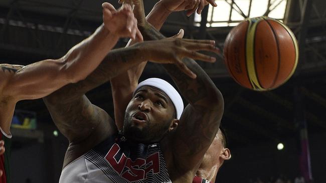 CORRECTING NAME OF PLAYERS US centre DeMarcus Cousins (C) vies with Mexico's forward Marco Ramos (L) and Mexico's centre Gustavo Ayon (R) during the 2014 FIBA World basketball championships round of 16 match USA vs Mexico at the Palau Sant Jordi arena in Barcelona on September 6, 2014. AFP PHOTO / LLUIS GENE