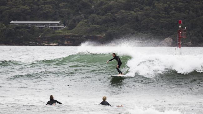 Surfers take advantage of the rare event of waves breaking at Shark Beach. Picture: Dylan Robinson