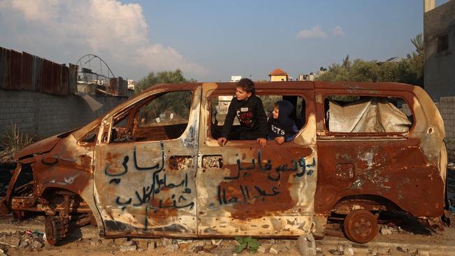 Boys play inside a car that was destroyed in an Israeli airstrike near the Nuseirat refugee camp in the central Gaza Strip on January 11. Picture: Eyad Baba/AFP