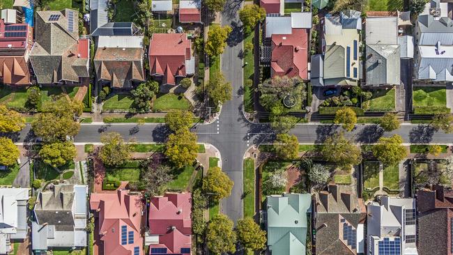 Aerial view of leafy eastern suburban houses on 4-way cross road intersection in Adelaide, South Australia: directly above, rooftop solar, trees. Housing property generic