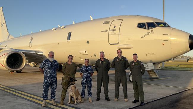 Sergeant Tony Weiler, Leading Aircraftwoman Caitland Evans, Military Working Dog Xal, Flying Officer Shahree Hodge, Squadron Leader Shane Trott, Flying Officer Patrick Neill and Warrant Officer Andrew Ribbans in front of a P-8A Poseidon aircraft at RAAF Base Townsville. Picture: WOFF Andrew Ribbans