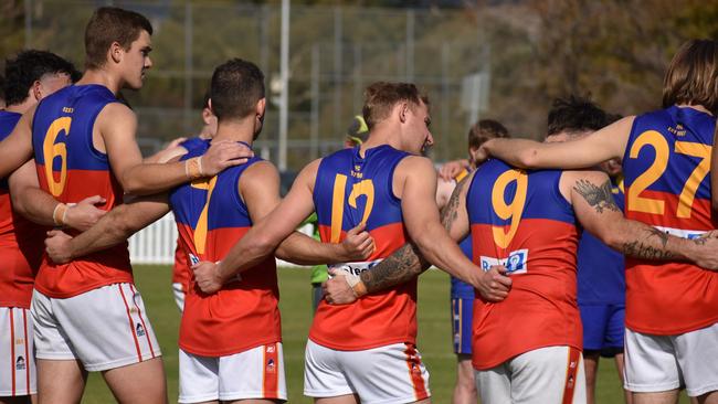 Fitzroy and Elizabeth players in a moment of reflection for domestic violence awareness before the game. Picture: Aaron Burgess