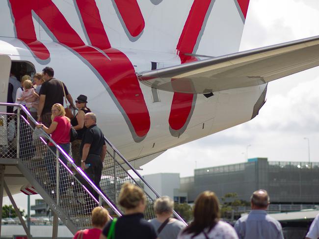 Passengers board a Virgin Australia Holdings Ltd. Boeing 737-800 aircraft at the domestic terminal of Sydney airport in Sydney, Australia, on Wednesday, Feb. 22, 2012. Australian business-class fares have fallen to record lows as Virgin Australia Holdings Ltd. challenges Sydney-based Qantas' grip on the market. Photographer: Ian Waldie/Bloomberg