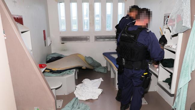 Officers comb through a room on the hunt for contraband. Picture: Peter Lorimer