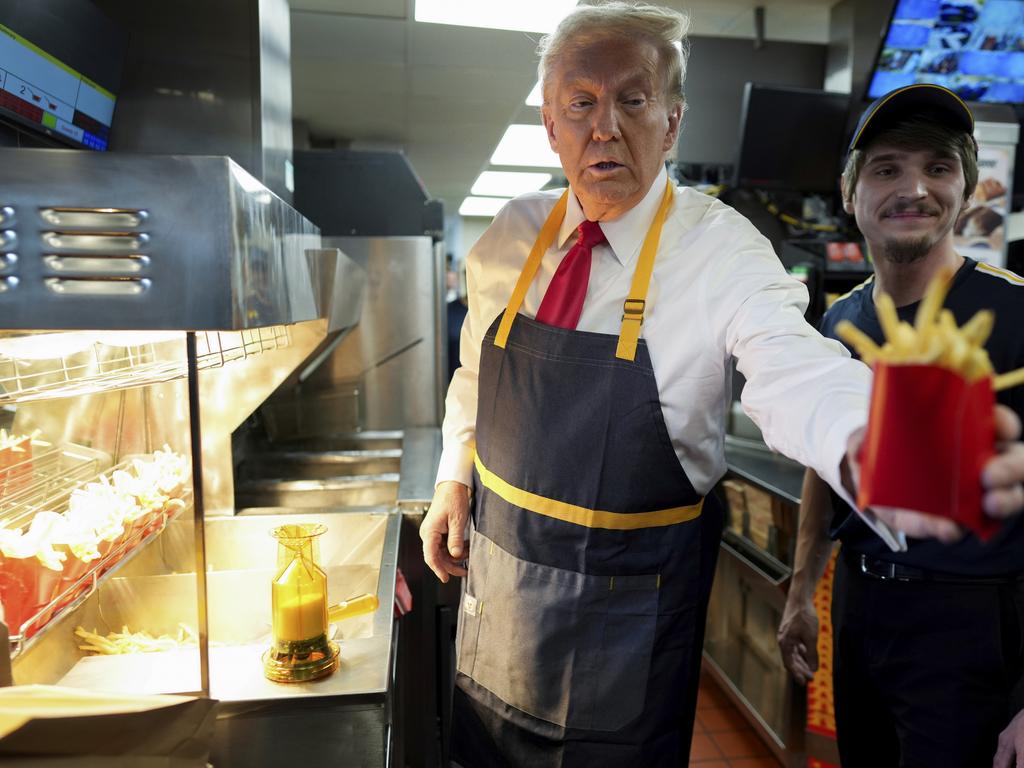 Republican presidential nominee former President Donald Trump hands off an order of fries after working at McDonald's. Picture: AP