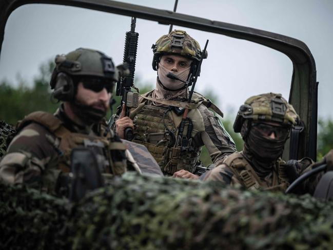 Soldiers of the French 3rd Foreign Infantry Regiment look on during the mission "Titan", which aims to protect the facilities of the launch sites of the Ariane VI in the forest around the Guiana Space Centre, in Kourou, French Overseas, on March 2, 2025. The French Air Force's Bubo Titan operation aims to secure the Ariane VI launch site for its first commercial flight, carrying the CSO-3 military observation satellite. (Photo by JULIEN DE ROSA / AFP)