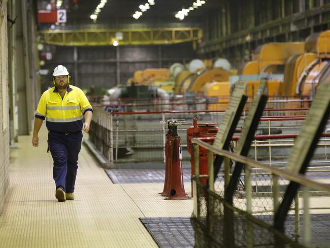 A worker walks past the turbine generator units at Hazelwood power station. Picture: David Caird