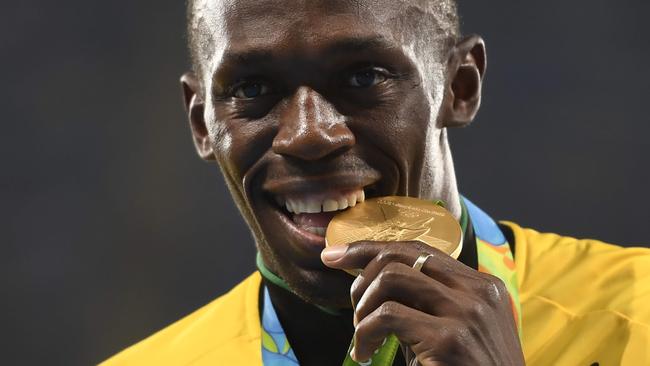 (FILES) This file photo taken on August 20, 2016 shows Gold medallist Usain Bolt standing on the podium during the medal ceremony for the Men's 4x100m final during the athletics at the Rio 2016 Olympic Games at the Olympic Stadium in Rio de Janeiro.   Jamaican sprint legend Usain Bolt labelled himself on August 1, 2017 the underdog as he seeks to round off his glittering individual track career with the defence of his world 100m title this week. / AFP PHOTO / Eric FEFERBERG