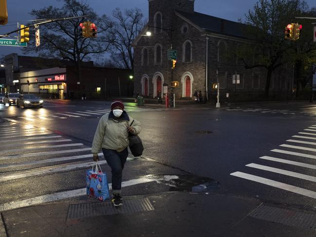 A woman wearing a mask crosses Church Avenue in the Brooklyn borough of New York. Picture: AP