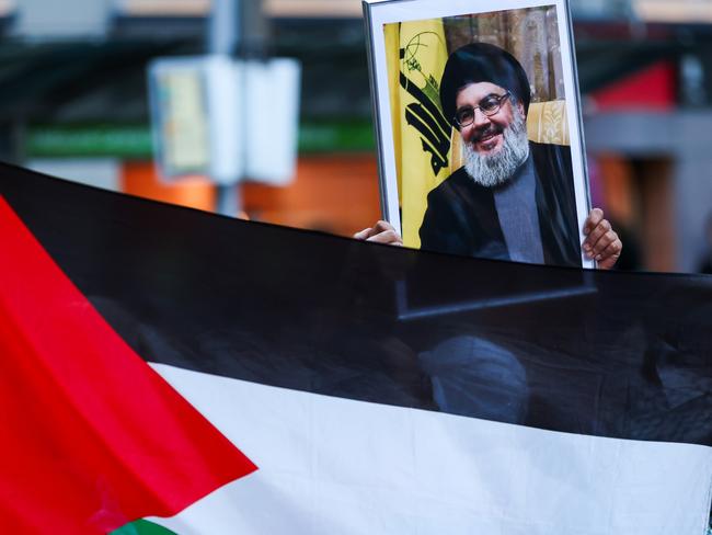 MELBOURNE, AUSTRALIA - OCTOBER 10: A portrait of Hassan Nasrallah is held up at a Pro-Palestine rally on October 10, 2023 in Melbourne, Australia. The Palestinian militant group Hamas launched a surprise attack on Israel from Gaza by land, sea, and air, over the weekend, killing over 600 people and wounding more than 2000, agency reports said. Reports also said Israeli soldiers and civilians have been kidnapped by Hamas and taken into Gaza. The attack prompted a declaration of war by Israeli Prime Minister Benjamin Netanyahu, and ongoing retaliatory strikes by Israel on Gaza killing hundreds in the aftermath. (Photo by Asanka Ratnayake/Getty Images)
