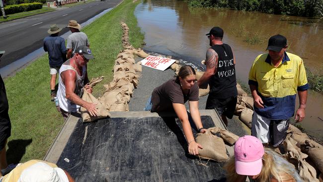 Locals of Maclean help sandbag the levee wall to prevent flood waters inundating the Main Street of the town along the Clarence River. Picture: Toby Zerna