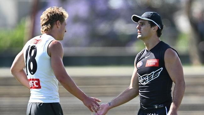 New Magpie Lachie Schultz (right) encourages young midfielder Finlay Macrae at Victoria Park on Monday. Picture: Quinn Rooney / Getty Images