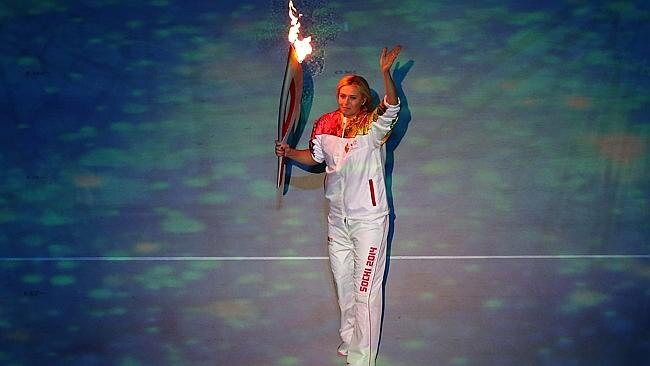 Tennis star Maria Sharapova carries the Olympic torch into the stadium during the Winter Olympics opening ceremony.