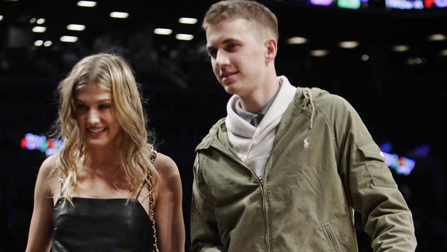 Genie Bouchard, walks the court with her blind date, John Goehrke, right, during the first half of an NBA basketball game between the Brooklyn Nets and the Milwaukee Bucks.