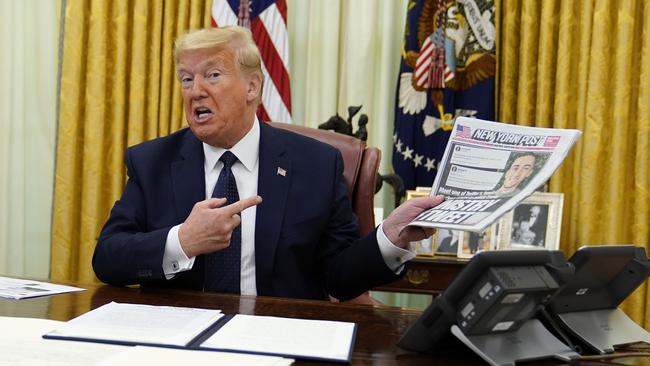 President Donald Trump holds up a copy of the New York Post as speaks before signing an executive order aimed at curbing protections for social media giants. Picture: AP.