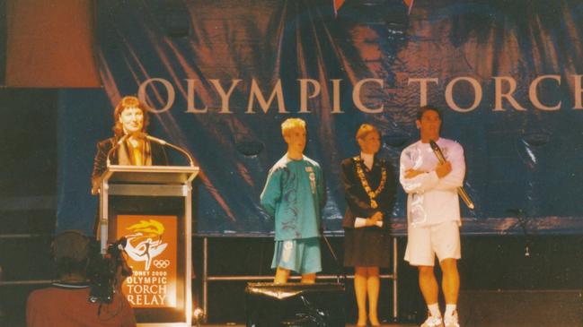 Lorraine Wearne (third from left) and Brad Fittler are poised to light the cauldron.