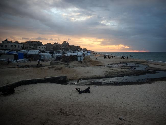 A Palestinian lies on the sand near tents used as temporary shelter in Deir el-Balah in the central Gaza Strip. Picture: AFP