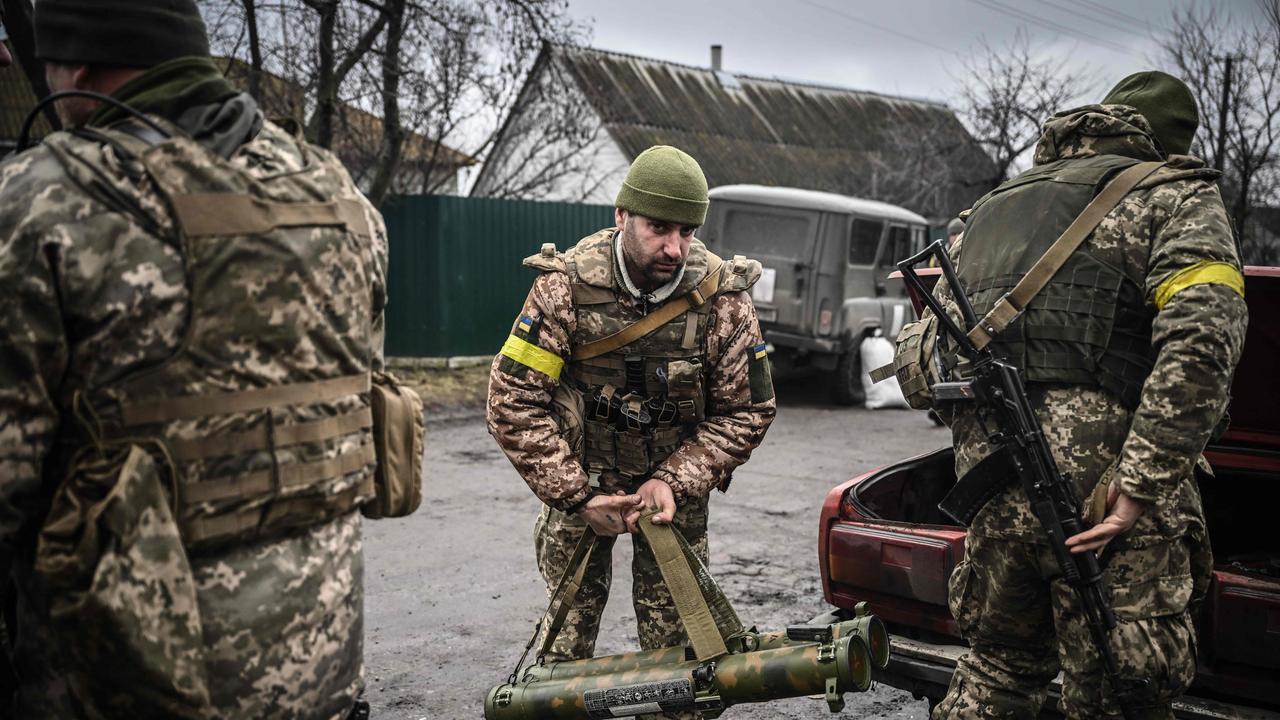 Ukrainian soldiers unload weapons from the trunk of an old car, northeast of Kyiv. Picture; Aris Messinis / AFP