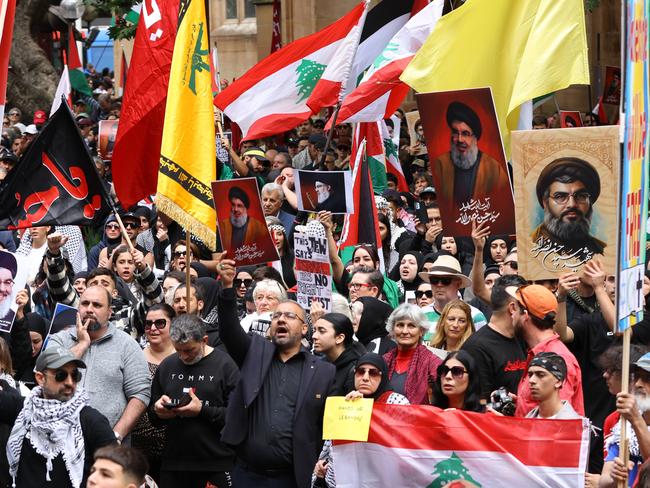 SYDNEY, AUSTRALIA - NewsWire Photos SEPTEMBER 29, 2024: People hold up pictures of Hezbollah leader Hassan Nasrallah and the Hezbollah flag at a protest at Town Hall in SydneyPicture: NewsWire / Damian Shaw