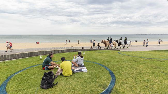 People sit in social distancing circles at St Kilda beach in Melbourne, Victoria. Picture: Daniel Pockett