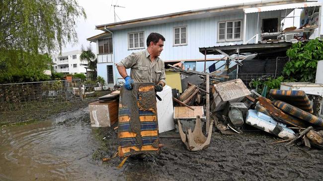 A man helps total strangers to remove flood-damaged items from their home in the suburb of Rosslea in Townsville, Thursday, February 7, 2019. Residents have begun cleaning up after days of torrential rain and unprecedented water releases from the city's swollen dam, sending torrents of water down the Ross River and into the city, swamping roads, yards and homes. (AAP Image/Dan Peled) NO ARCHIVING. Picture: DAN PELED