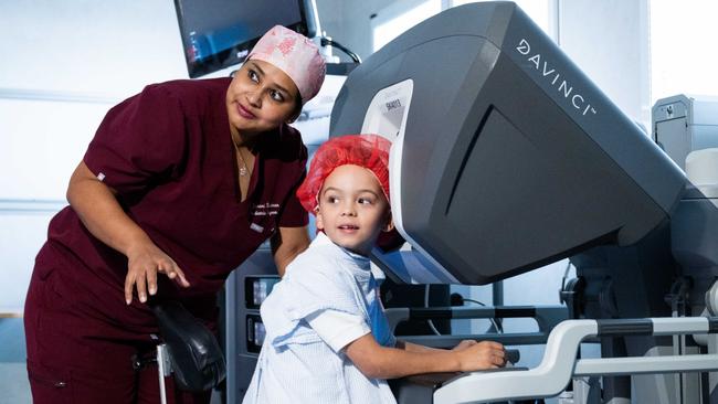 Dr Janani Krishnan and Charters Towers boy Kruze Bott with the da Vinci Xi surgical assist robot that helped him. Picture: Mater Private Hospital Townsville