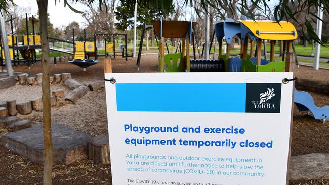 A sign is displayed in front of a closed playground.