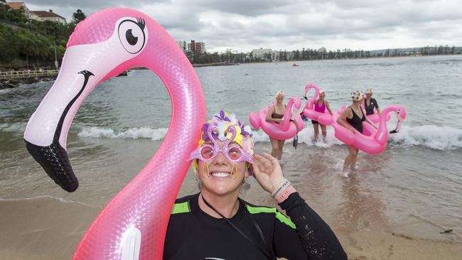 Jo Moffitt-Goulding poses for a photograph while fellow Flocking 50 and Fabulous Floating Flamingos members test the water before the annual Manly Inflatable Boat Race at Shelly Beach at Manly on Sunday, 23 February, 2020. Picture: Troy Snook