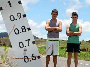 Travis Lowe, 14 (left) and Brad Austin, 17 along with their friend Josh Mazzaracca, 20 helped a woman restart her car after it was ruined by floodwaters at Freestone. Picture: Kirstin Payne 