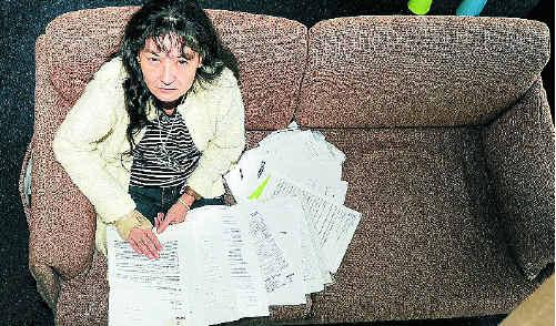 Christine Anderson with some of the documentation related to the auction of her home after payment of her land rates had lapsed. 