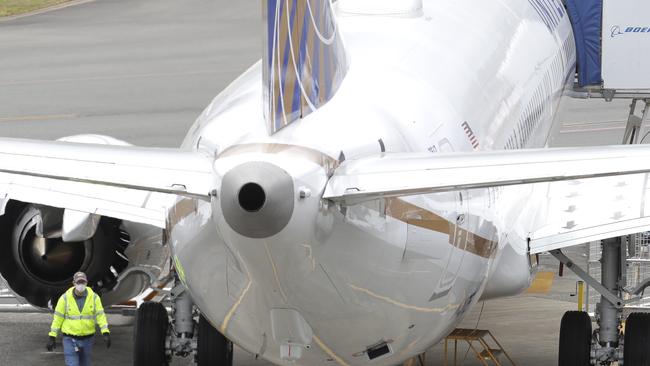 A Boeing Co. worker wearing a mask walks near a 737 Max aeroplane owned by United Airlines. Picture: AP.