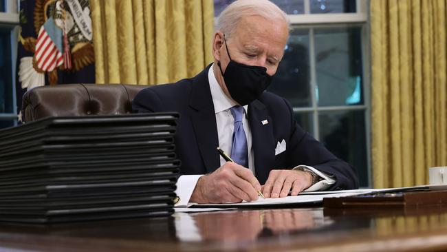 US President Joe Biden prepares to sign a series of executive orders at the Resolute Desk in the Oval Office just hours after his inauguration. Picture: Chip Somodevilla/Getty Images