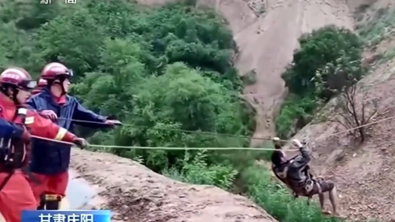 Emergency personnel in Qingyang, Gansu province, have used ropes to evacuate trapped workers after flooding, road collapses and landslides caused by Typhoon Doksuri. Picture: CCTV13