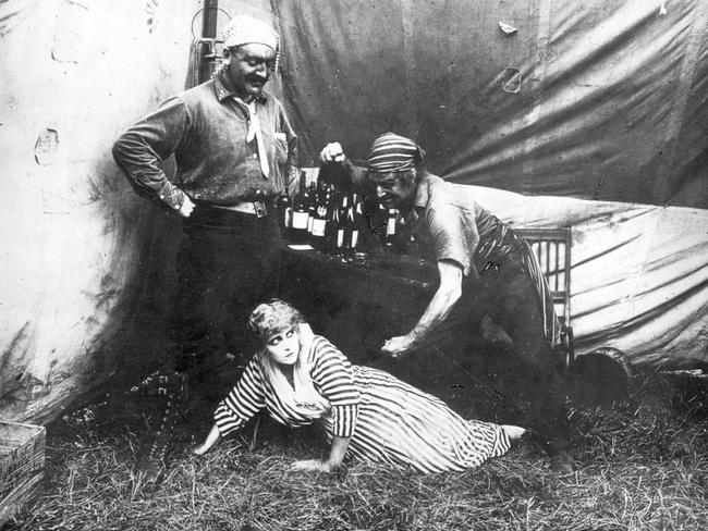 Pearl White and two unidentified men in a scene from the 1914 film serial, The Perils of Pauline.