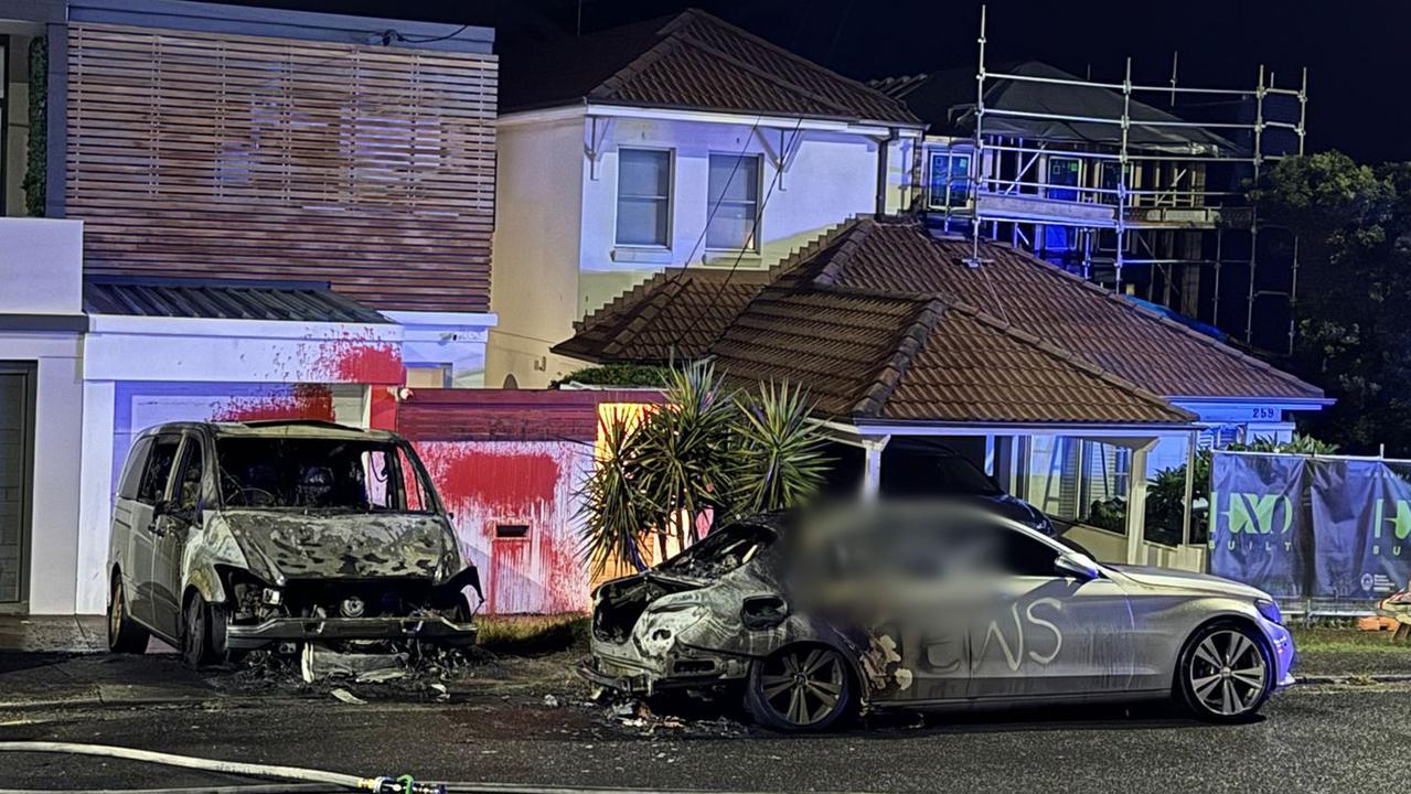 One of the torched cars and the home that had red paint thrown over it.