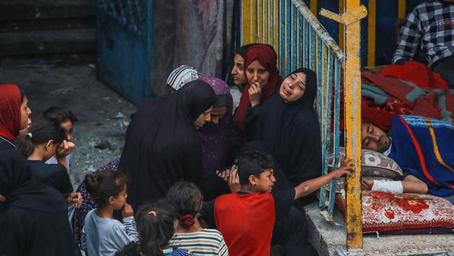 Palestinians react at a UN-school housing displacing people that was hit during Israeli bombardment.