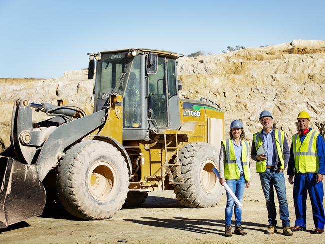 CAREERS: jobs in the mining, resources and energy sector are growing. Picture: iStockFull length portrait of confident architects and worker standing by bulldozer at quarry