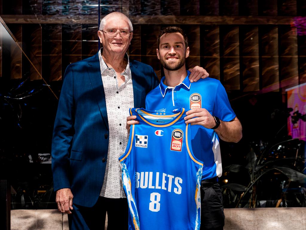 Brisbane's greatest coach Brian Kerle, who led the Bullets to four consecutive NBL grand finals winning two titles, presents Mitch Norton his No.8 jersey at the club's season launch, earlier this season.