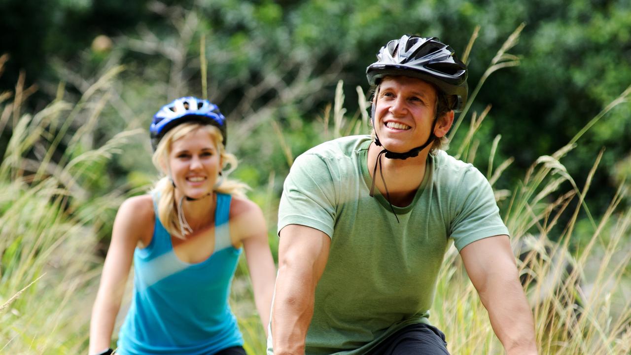 A happy couple riding bicycles outside. Those broad smiles would fit in well in Tasmania.