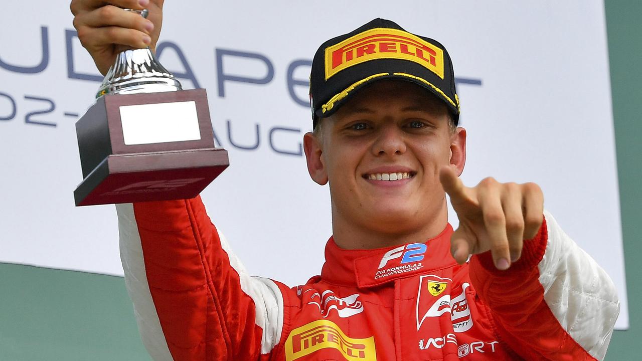 Mick Schumacher celebrates with his trophy on the podium at the Hungaroring.