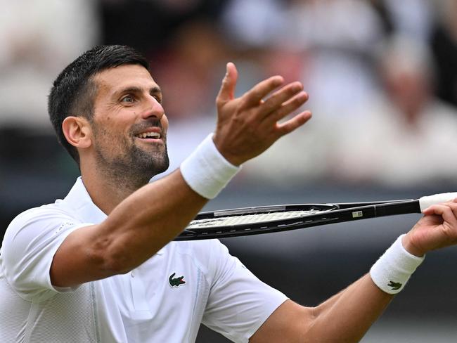 TOPSHOT - Serbia's Novak Djokovic imitates playing the violin with his racquet as he celebrates winning against Italy's Lorenzo Musetti during their men's singles semi-final tennis match on the twelfth day of the 2024 Wimbledon Championships at The All England Lawn Tennis and Croquet Club in Wimbledon, southwest London, on July 12, 2024. Djokovic won the match 6-4, 7-6, 6-4. (Photo by ANDREJ ISAKOVIC / AFP) / RESTRICTED TO EDITORIAL USE