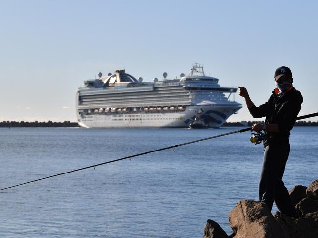 A man fishes as the Ruby Princess cruise ship prepares to dock at Port Kembla. Picture: AAP