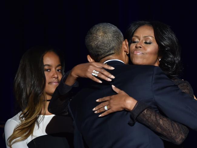 Michelle Obama hugs President Barack Obama as daughter Malia looks on after he delivered his farewell address in Chicago. Picture: Nicholas Kamm