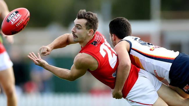 Alex Spina fires off a handball under pressure from Adelaide’s Lachlan Murphy. Picture CALUM ROBERTSON