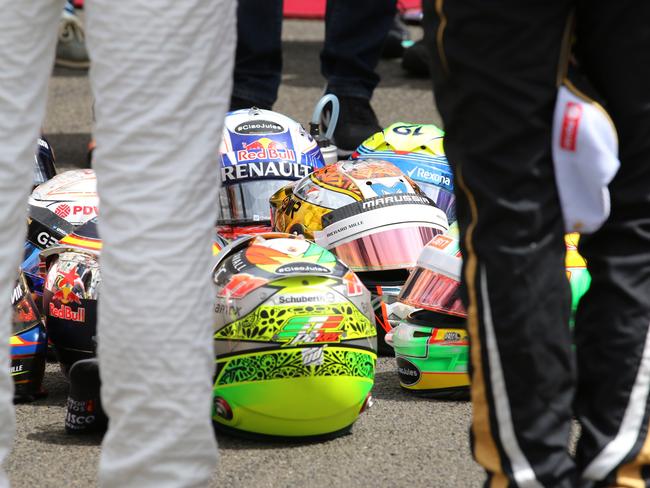Helmets of drivers lay on ground as forming a circle during minute’s silence.