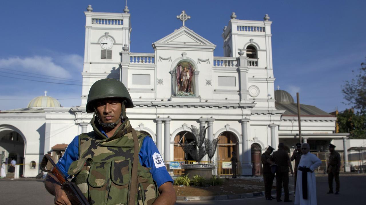 Sri Lankan air force officers and clergy stand outside St. Anthony's Shrine, a day after a blast in Colombo. Picture: AP 