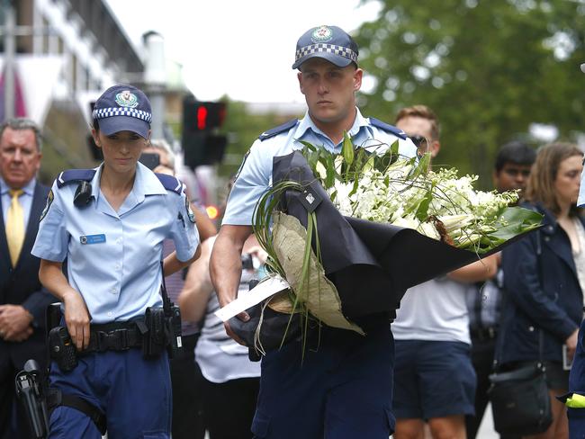 Police officers visit the flower memorial. Picture: Bradley Hunter