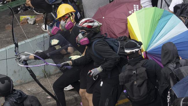 Masked protesters armed with powerful bows clash with police at the Hong Kong Polytechnic University on Monday. Picture: AP