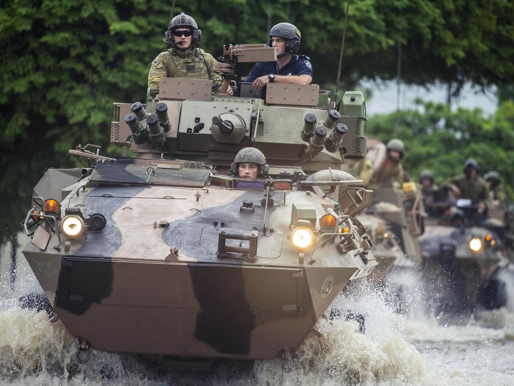 Australian soldiers drive through flood waters in Hermit Park, Townsville. Picture: Glenn Hunt/The Australian